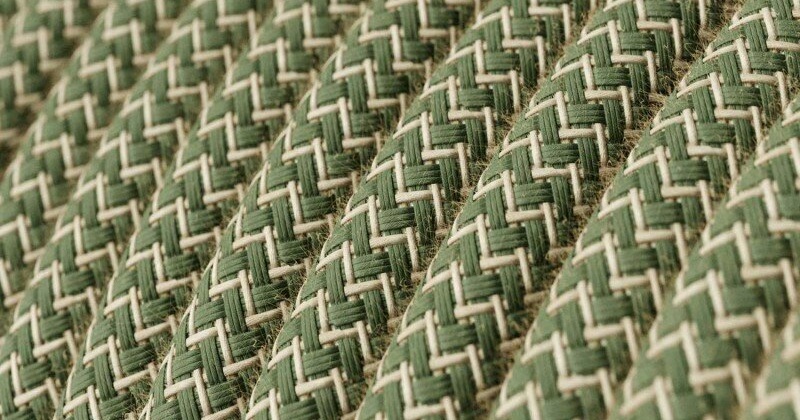 Macro van de gevlochten textielmantel van groen strijkijzersnoer