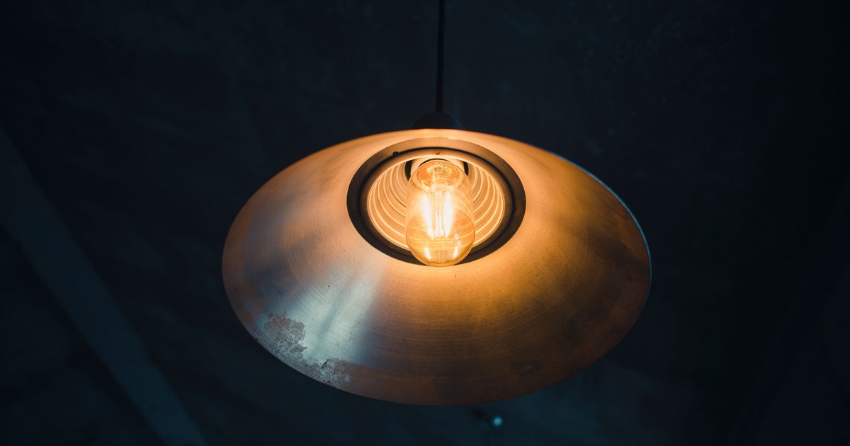 Metalen industriële hanglamp met warme lichtbron en zichtbare kap