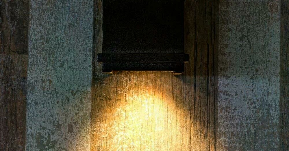 Een wandlamp geeft warm licht op de gevel