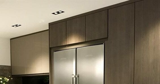 Dubbele spots verwerkt in een gestuct plafond, gefotografeerd boven een keuken