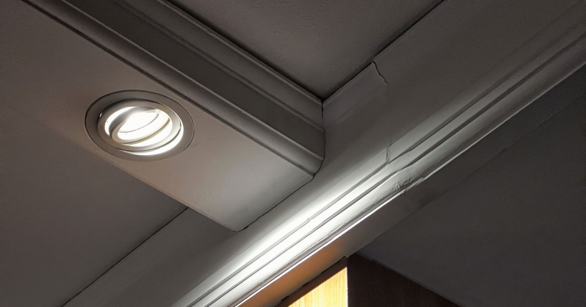 Gekantelde inbouwspot met gericht licht op houten wand
