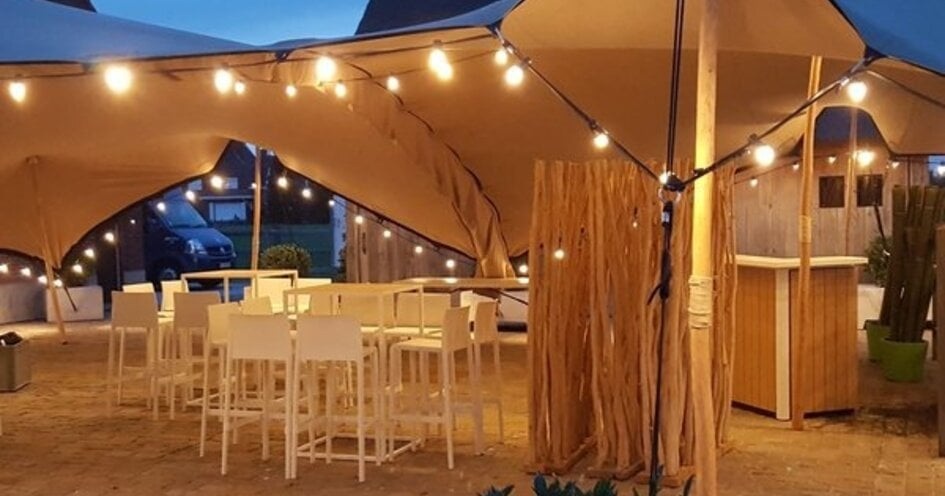 Warmwitte prikkabels boven een buitenterras met tentdoek